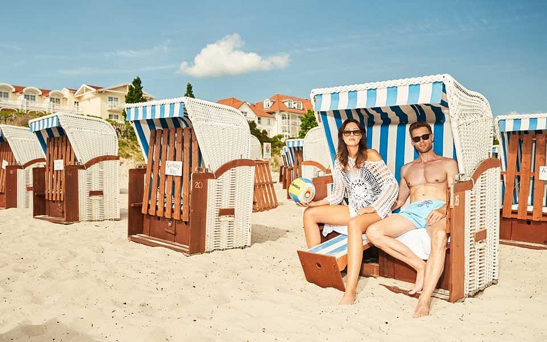 Paar sitzt am Ostseestrand in Badekleidung im Strandkorb