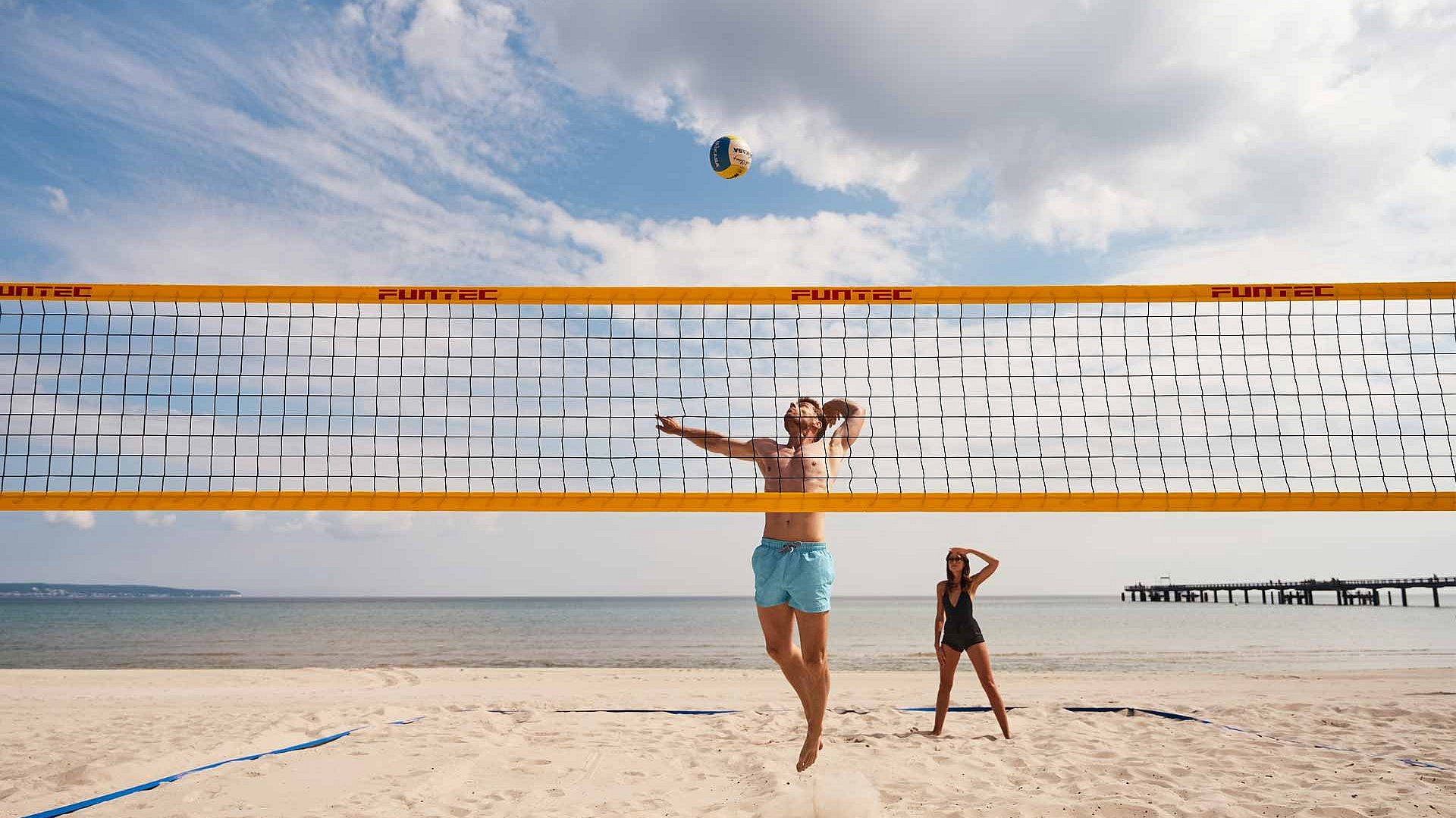 Paar spielt Beach-Volleyball am Ostseestrand