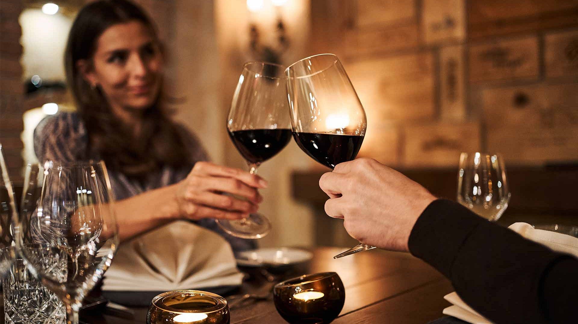 Couple toasts with red wine in restaurant